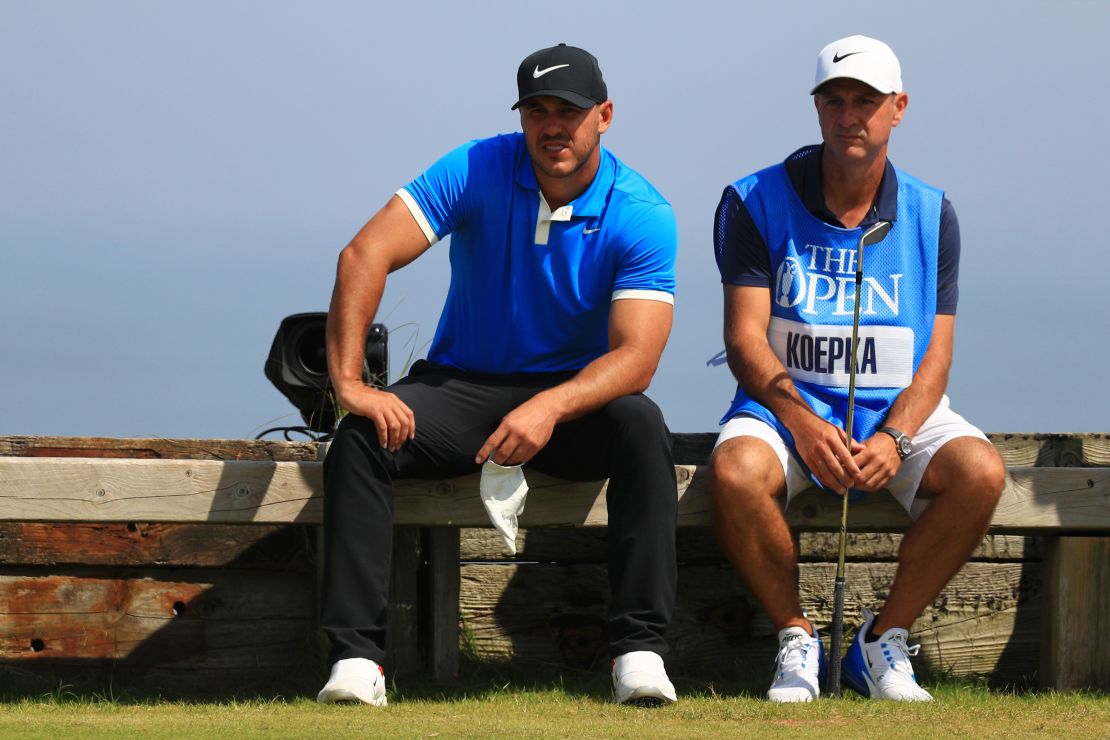 Brooks Koepka and caddie Ricky Elliott rest during a practice round at Royal Portrush.