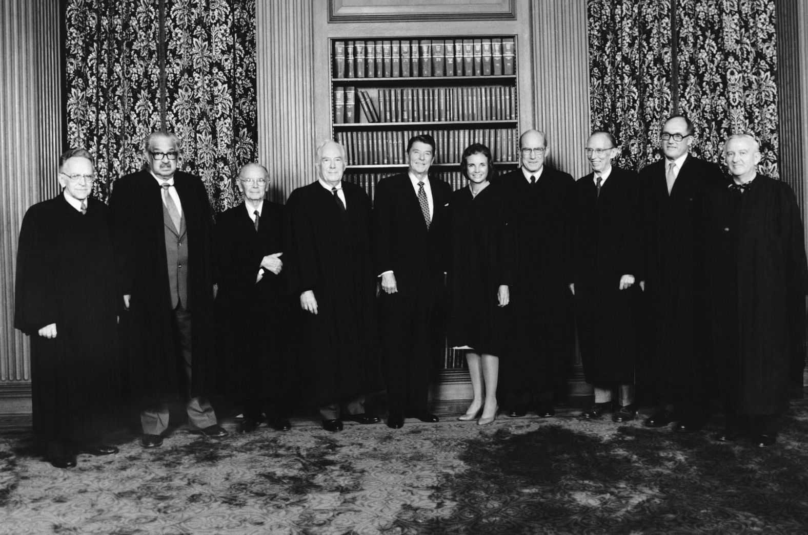 In this photo provided by the White House, the nine justices of the Supreme Court, including the newly sworn-in Sandra Day O'Connor, pose with President Reagan in the conference room of the Supreme Court on September 25, 1981. From left are Harry A. Blackmun, Thurgood Marshall, William J. Brennan, Chief Justice Warren Burger, President Reagan, O'Connor, Byron White, Lewis Powell, William Rehnquist and Stevens. 