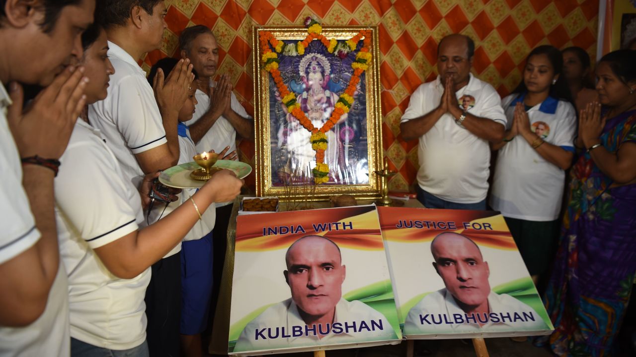 Indian residents in Mumbai offer prayers next to placards showing Kulbhushan Jadhav, an Indian national convicted of spying in Pakistan, July 17, 2019.
