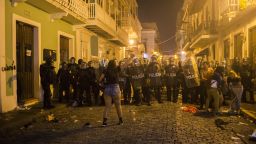 A demonstrator reacts in front of the police during clashes in San Juan, Puerto Rico, Wednesday, July 17, 2019. Thousands of people marched to the governor's residence in San Juan on Wednesday chanting demands for Gov. Ricardo Rossello to resign after the leak of online chats that show him making misogynistic slurs and mocking his constituents. (AP Photo/Dennis M. Rivera Pichardo)