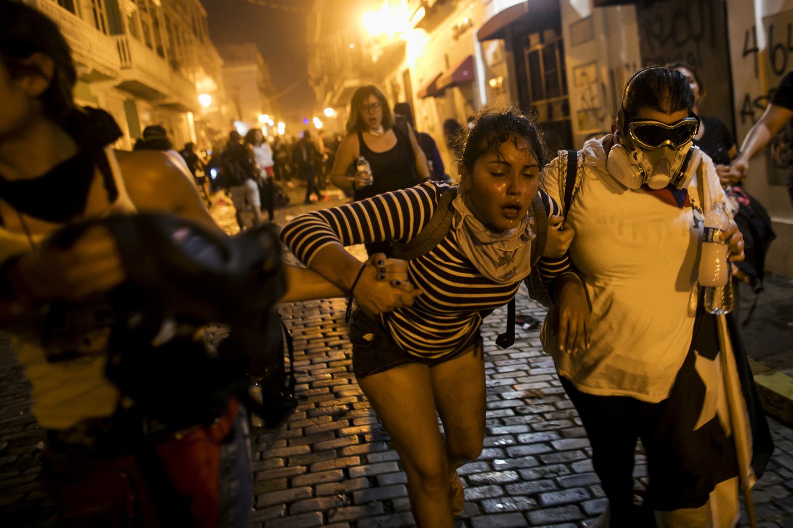 A woman is assisted in the streets after demonstrators clashed with police on Wednesday, July 17.