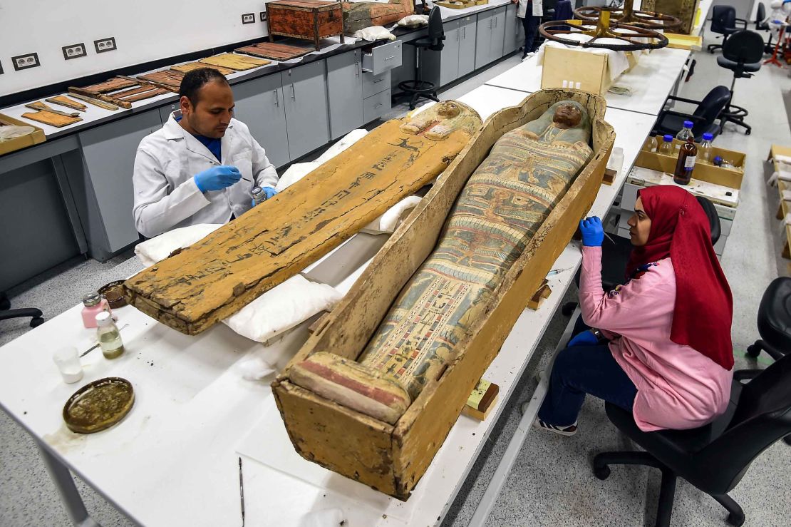 Staff at the Grand Egyptian Museum restoration lab work on a sarcophagus from the Tutankhamun collection.