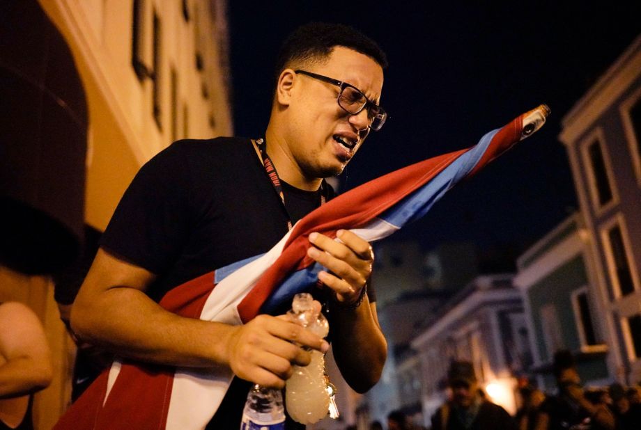 A protester reacts after being sprayed by tear gas in San Juan.