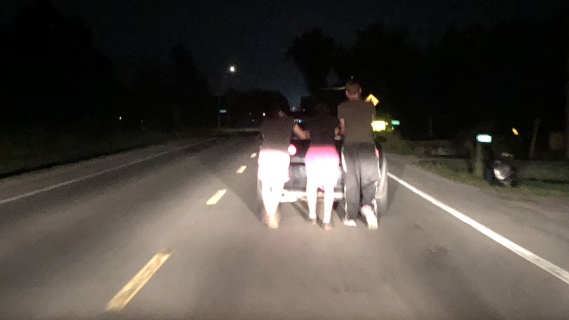 Aeron McQuillin, Bailey Campbell, Billy Tarbett push a stranded motorist's car home.