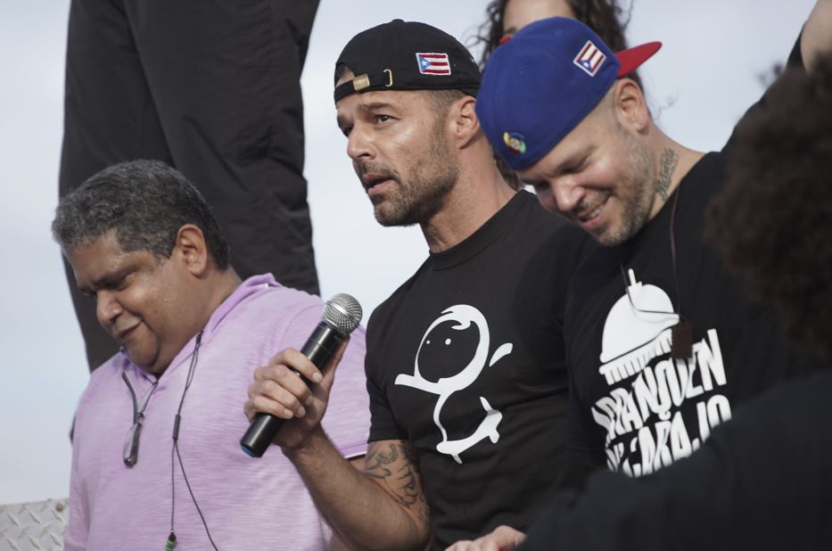 Ricky Martin holds a microphone during the march on July 17. At right is rapper Rene Perez, aka Residente.