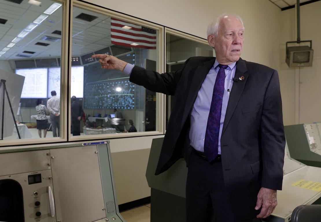 Spencer Gardner stands next to the newly restored Mission Control room in June 2019.