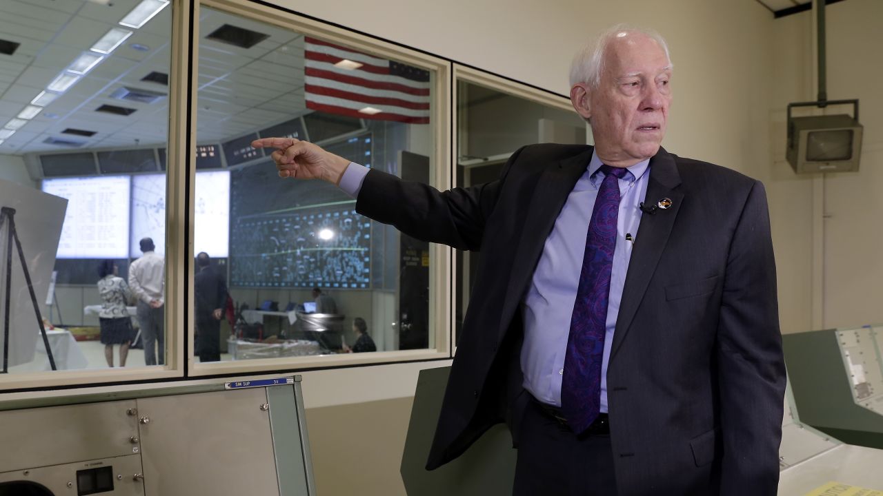 Spencer Gardner stands next to the newly restored Mission Control room in June 2019.