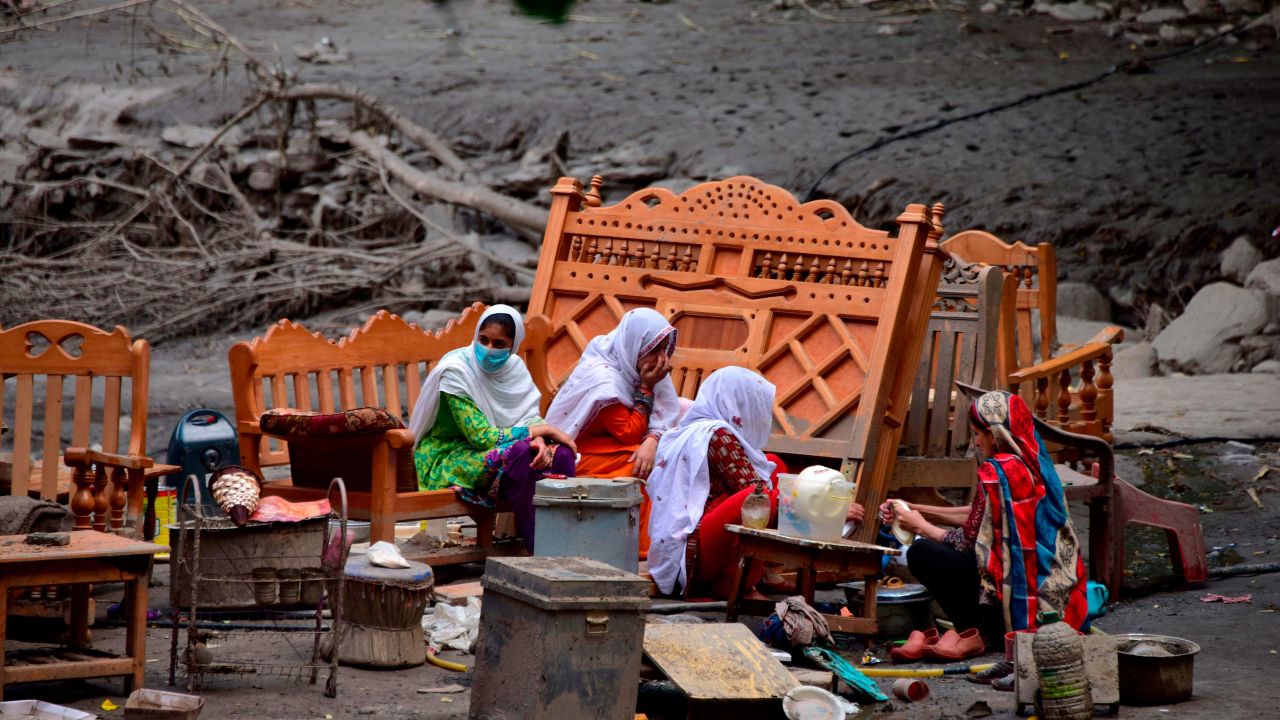 A family in Pakistan-controlled Kashmir outside their damaged house on July 16, 2019.