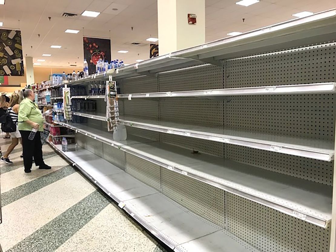 Shoppers look at empty shelves as large jugs of water are sold out at a supermarket after the water main break in Fort Lauderdale.