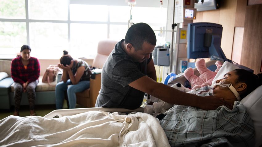 Miguel Gámez, father of Heydi Nallely Gámez Garcia, touches the bruises on his daughter's neck and his sister Jessica Gámez Garcia cries in the background as Heydi lays on life support in Cohen Children's Medical Center in Queens, NY on July 17, 2019. CREDIT: Mark Kauzlarich for CNN