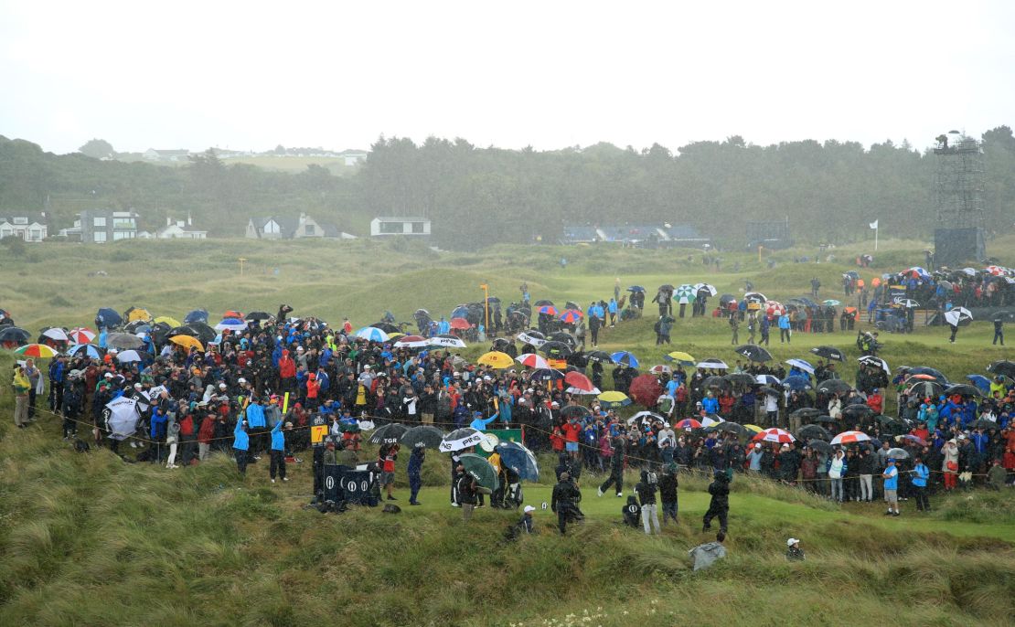 Tiger Woods drives off the seventh tee in a deluge. 