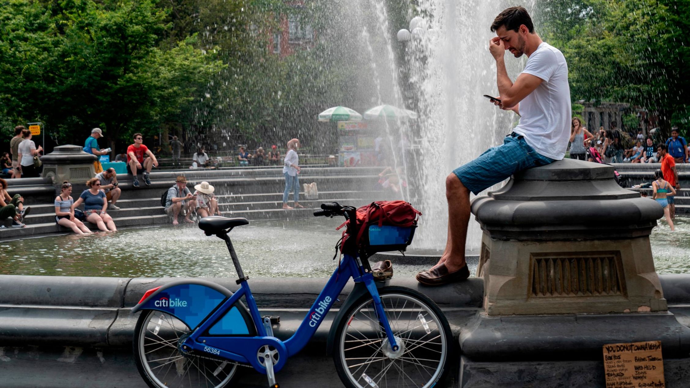 People cool off near the fountain at Washington Square Park on a hot Wednesday afternoon in New York City. 