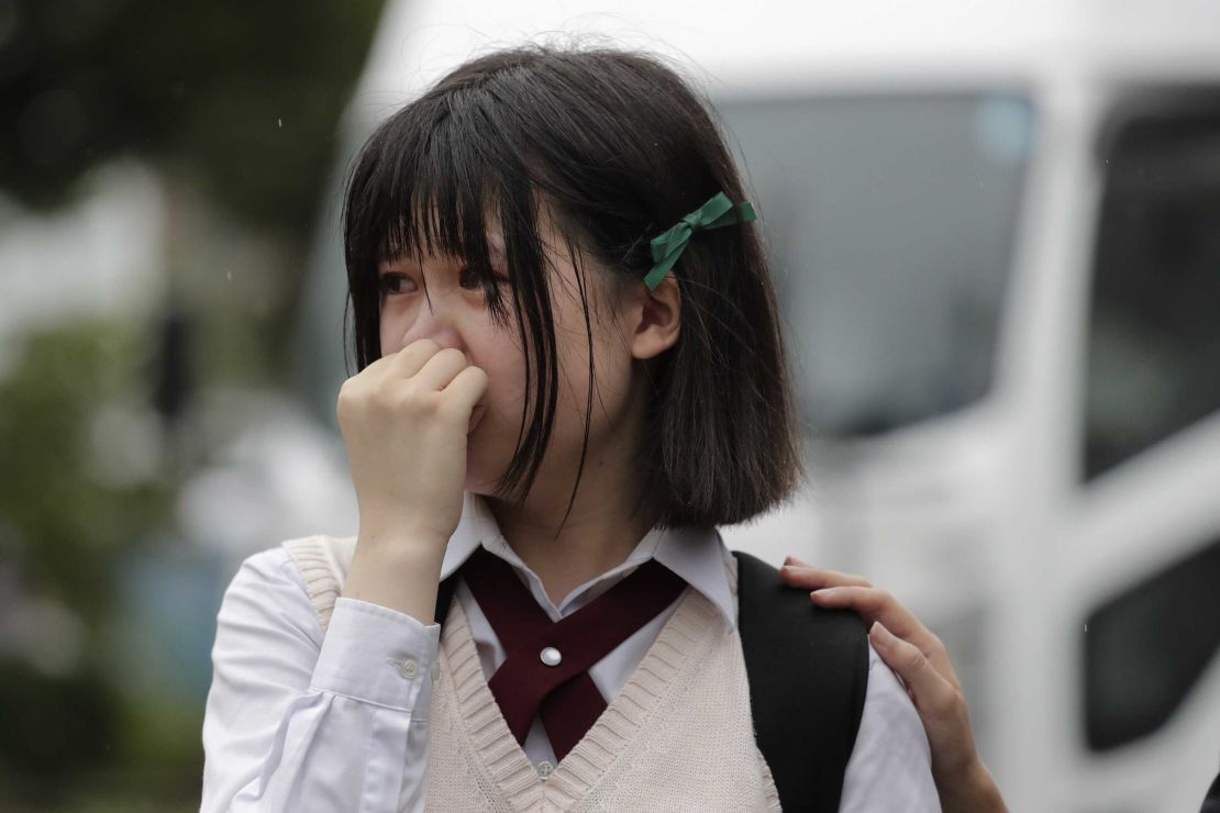 A woman in tears at a makeshift memorial honoring the victims of Thursday's fire.