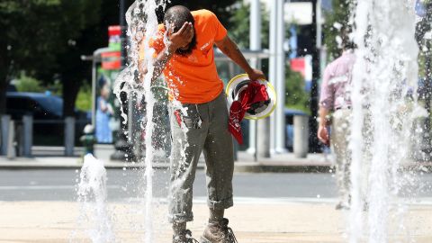 A construction worker stops to cool off in the water fountains at Canal Park in Washington.