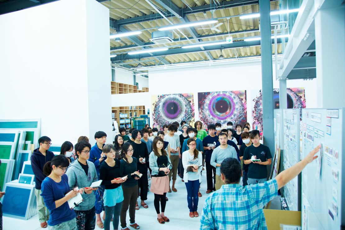 Takashi Murakami working in his studio with his assistants.