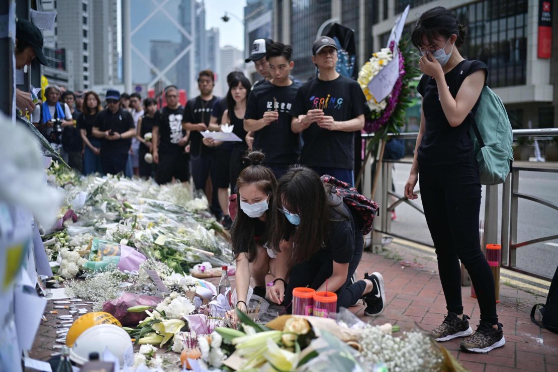 Mourners in Hong Kong place flowers and offer prayers on June 16, 2019, at the site where a protester died.