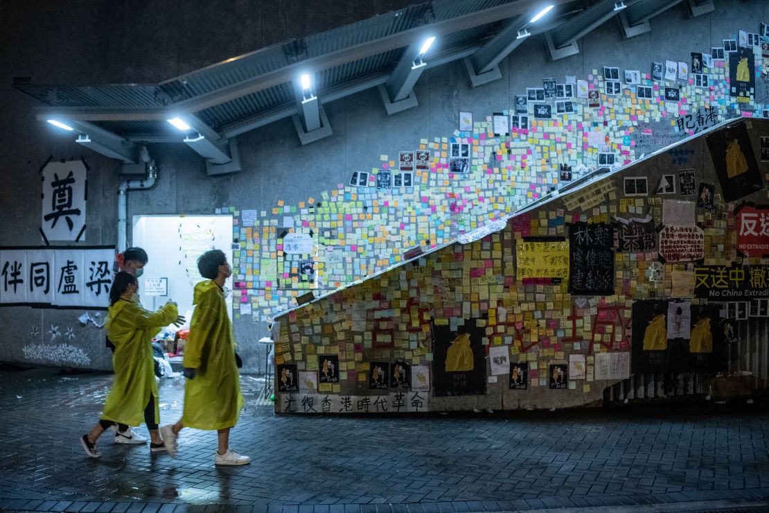 People walk in front of a so-called "Lennon Wall" where messages of support have been left for anti-extradition bill protesters on July 1, 2019 in Hong Kong.