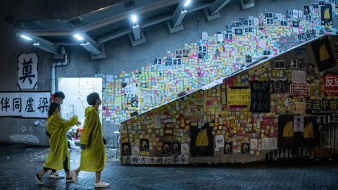 People walk in front of a so-called "Lennon Wall" where messages of support have been left for anti-extradition bill protesters on July 1, 2019 in Hong Kong.