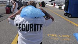 Track security officer Patty Patterson carries a bag of ice on her shoulders as she walks back to her post during a NASCAR Cup Series auto race practice at New Hampshire Motor Speedway in Loudon, New Hampshire, on July 20.