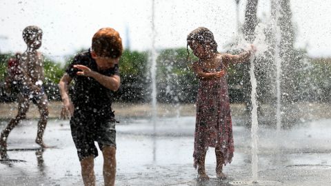 Children cool down by playing in a public fountain during the summer heat on July 19 in New York.