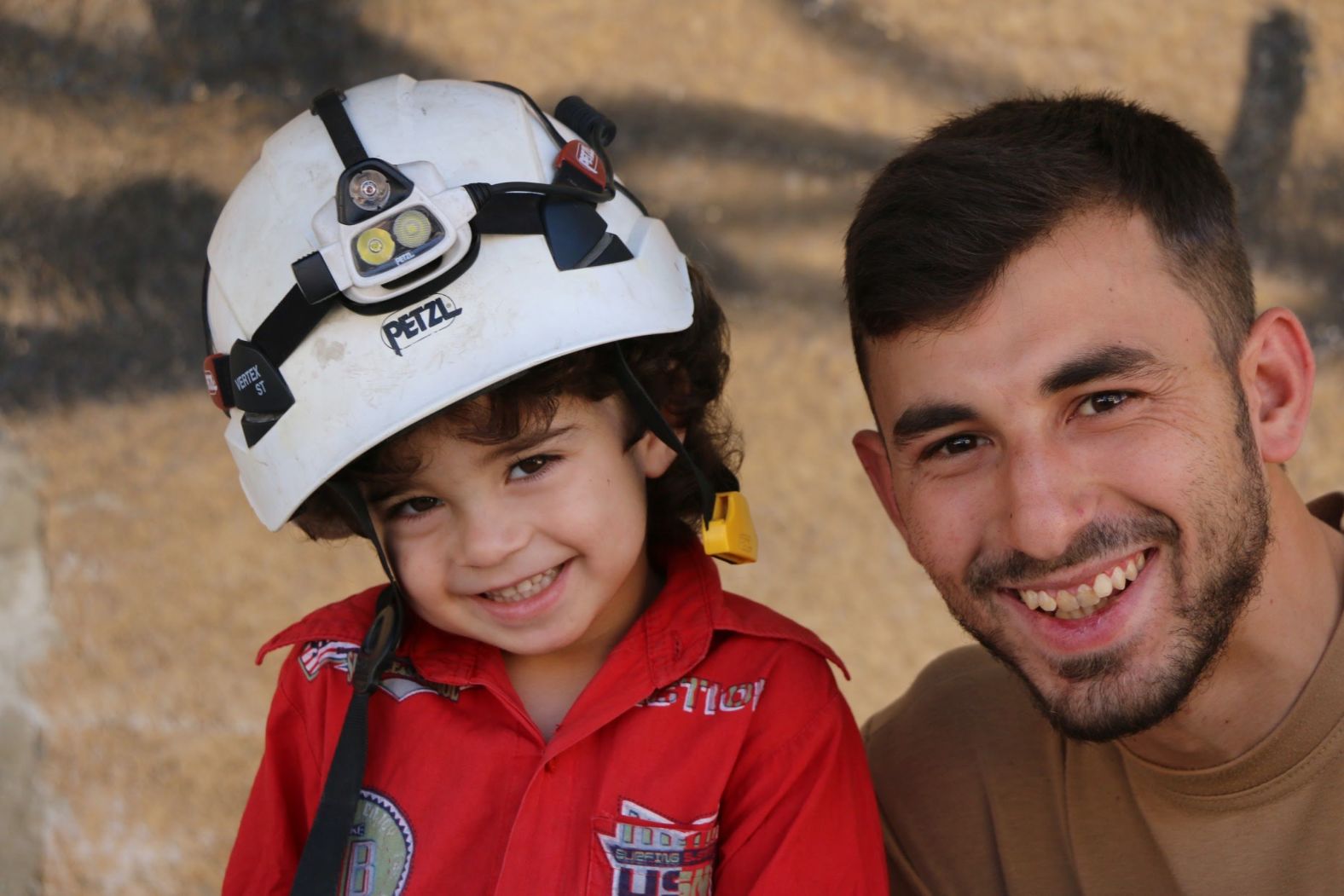 Al-Dyab poses for a portrait with a young girl. In photos that Kutini shared with CNN, al-Dyab is often seen interacting with young children, showing them photos from his camera or just talking to them.
