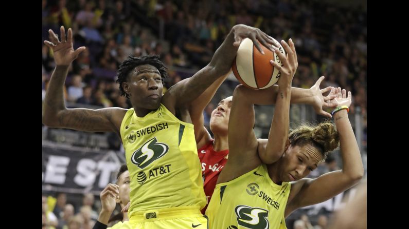Seattle Storm's Natasha Howard, left, and Mercedes Russell, right, compete for a loose ball with Las Vegas Aces' Liz Cambage during the first half of a WNBA basketball game in Seattle on Friday, July 19.
