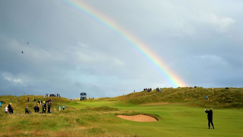 A rainbow appears over Royal Portrush Golf Club as Darren Clarke of Northern Ireland plays his second shot on the seventh hole during the first round of the Open Championship Portrush, Northern Ireland, on Thursday, July 18.