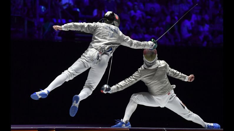 Enrico Berre of Italy, left, and Matyas Szabo of Germany compete in the men's team sabre bronze match of the FIE World Fencing Championships in Budapest, Hungary, on Sunday, July 21.
