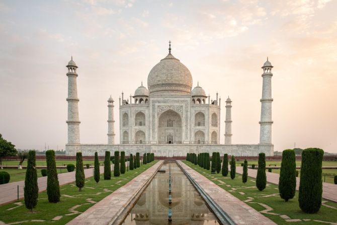 <strong>Taj Mahal (India):</strong> The sun rises over the Taj Mahal, a white marble mausoleum built with nearly perfect geometric architecture on the banks of the Yamuna River in the city of Agra.