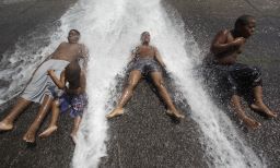 Kids play in an open fire hydrant during the heat wave in Detroit.