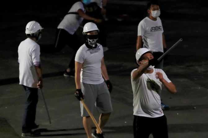 Masked men in white T-shirts are seen after <a href="index.php?page=&url=https%3A%2F%2Fedition.cnn.com%2F2019%2F07%2F23%2Fasia%2Fhong-kong-triad-arrests-intl-hnk%2Findex.html" target="_blank">attacking anti-extradition bill demonstrators</a> at a train station in Yuen Long.