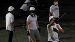 Men in white T-shirts with poles are seen in Yuen Long after attacking anti-extradition bill demonstrators at a train station, in Hong Kong, China July 22, 2019. REUTERS/Tyrone Siu