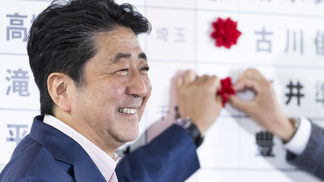 Japanese Prime Minister and ruling Liberal Democratic Party (LDP) President Shinzo Abe places a red paper rose on a LDP candidate's name to indicate an upper house election victory on July 21, 2019 in Tokyo, Japan.