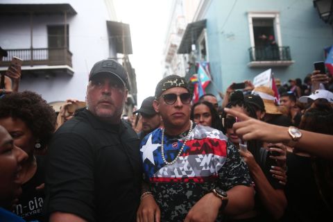 Singer Daddy Yankee, in the flag shirt, attends the rally on Monday.