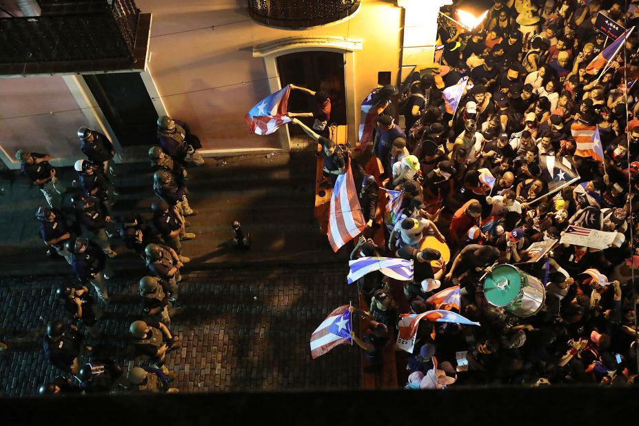 Protesters demonstrate near a police  barricade set up along a street leading to the governor's mansion.