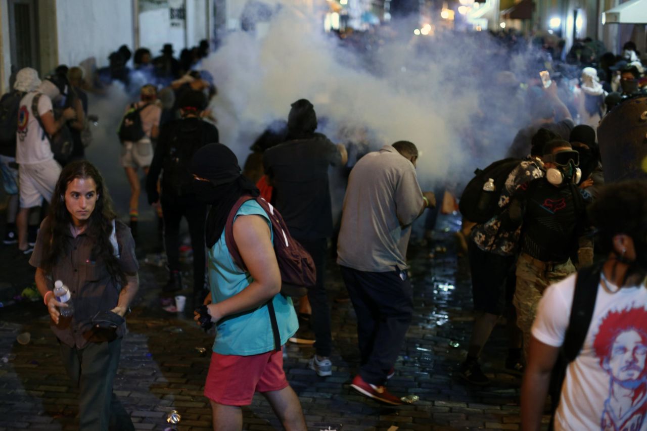 Protesters disperse in a cloud of tear gas.