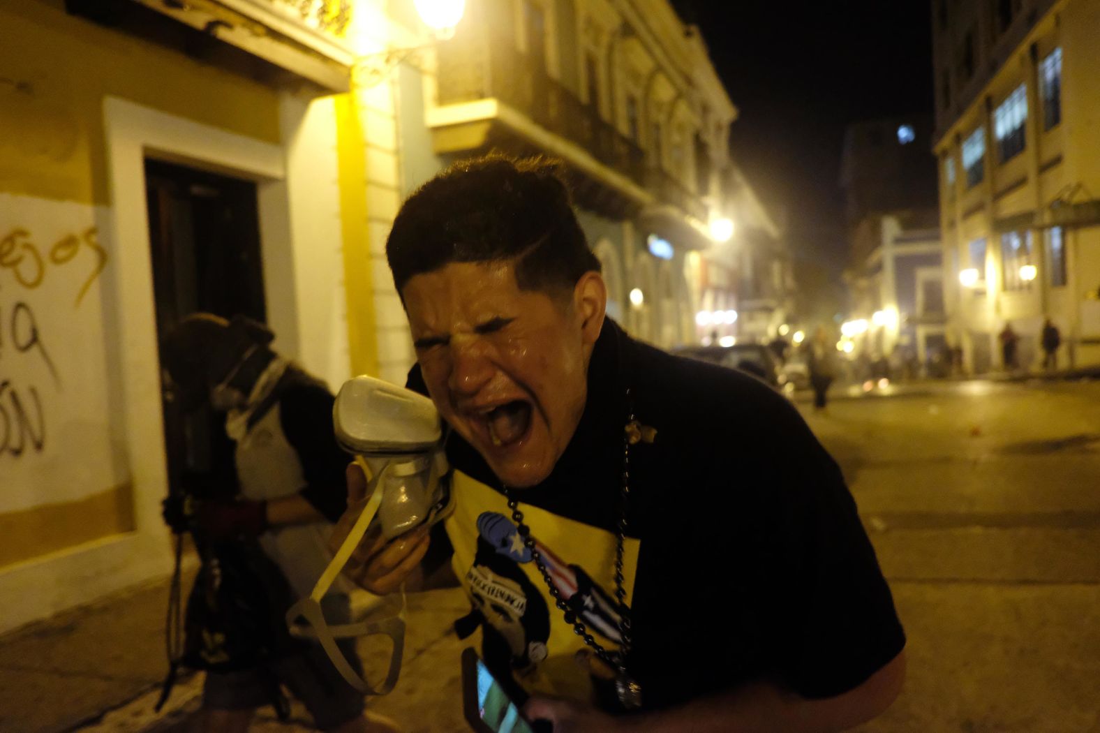 A protester reacts to tear gas outside the governor's mansion.