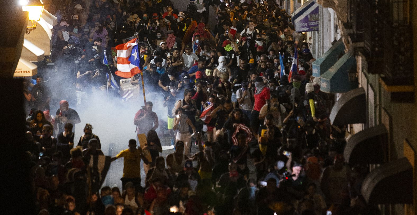 Protesters run away from tear gas near the governor's mansion. 