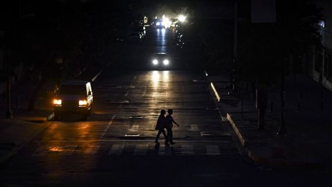 People crossing a street in Caracas on July 22, 2019 as the capital and other parts of Venezuela are being hit by a massive power cut.