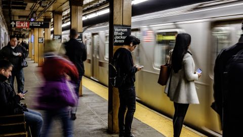 Commuters stand on the platform while waiting for the 7 train at the Vernon Boulevard-Jackson Avenue subway station in the Long Island City neighborhood in the Queens borough of New York, U.S., on Friday, Nov. 9, 2018. As reports emerged this week that Amazon.com Inc. was close to an agreement to set up a new office hub in Long Island City, the prospect of all those jobs, shoppers, and potential tenants or homebuyers drew cheers in the fast-growing neighborhood across the East River from Manhattan. Photographer: Christopher Lee/Bloomberg via Getty Images