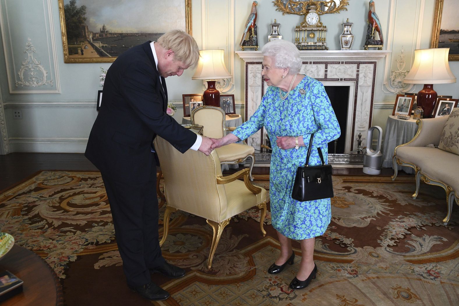 Britain's Queen Elizabeth II welcomes Johnson at Buckingham Palace, where she invited him to become Prime Minister and form a new government.