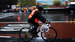 A delivery man rides his bike in the rain to deliver food in New York on November 17, 2014. The coldest air since last winter is set to move into the East during the first few days of the week, with high temperatures from Washington, DC, through New York City forecast to stay near or below freezing 32F (0C) on Tuesday, levels that would be considered below normal even during the heart of winter. AFP PHOTO/Jewel Samad        (Photo credit should read JEWEL SAMAD/AFP/Getty Images)