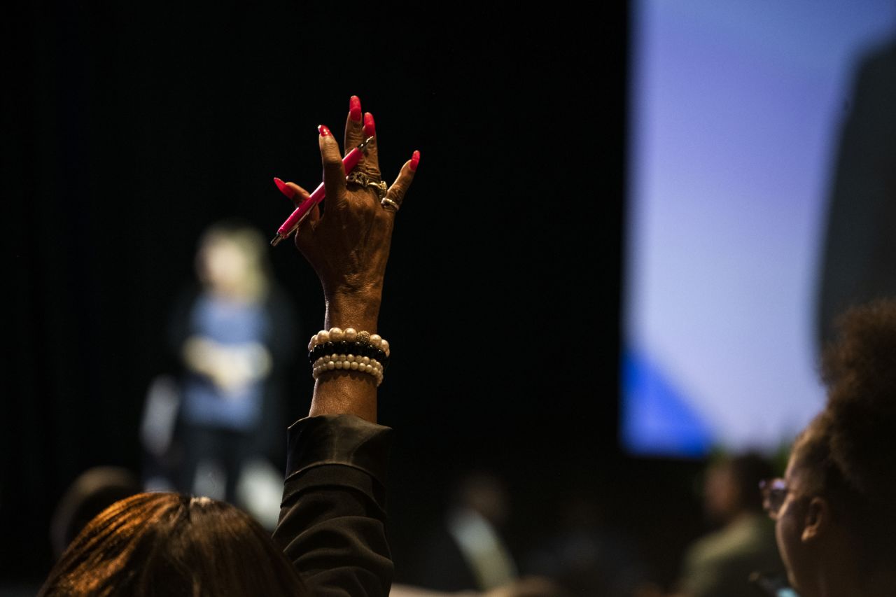 A woman raises her hand during Warren's closing remarks.