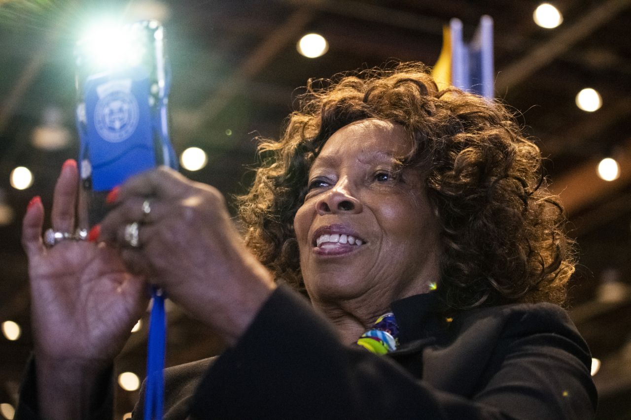 H. Scottie Coads, of Long Island, New York, takes a photo as Harris speaks on stage.