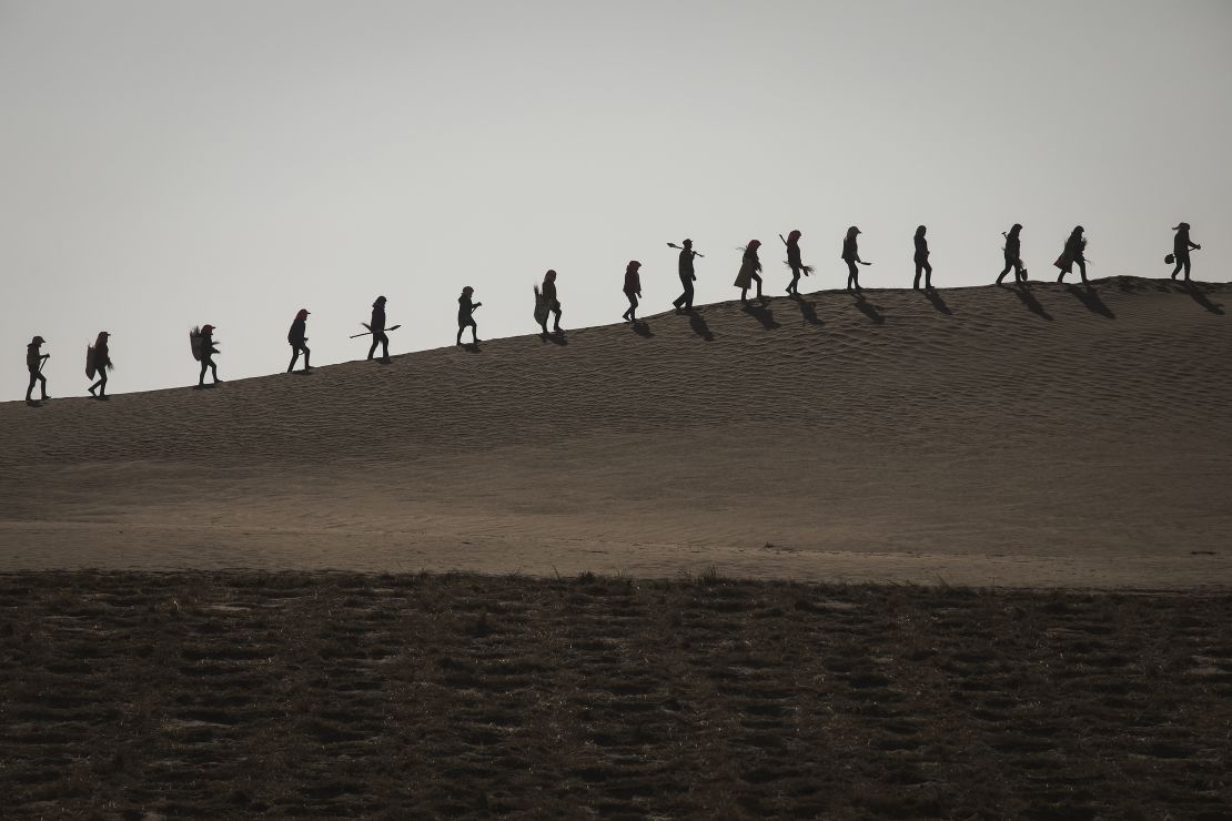 Local people planting trees in the desert in Mingqin county, Gansu Province, China on March 28, 2019.