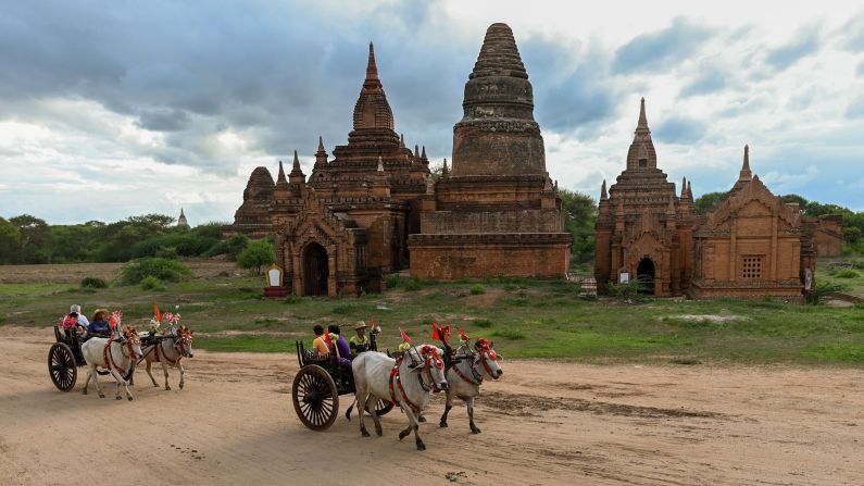 <strong>Bagan, Myanmar: </strong>Tourists riding bull carts pass a Buddhist temple in the ancient city of Bagan. 