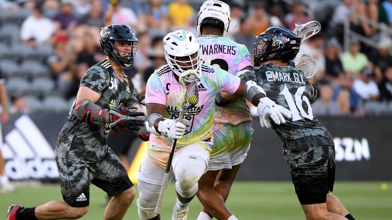 Trevor Baptiste #9 of Team Baptiste carries the ball between Mark Glicini #16 and Jake Frocarro #54 of Team Rambo during the Premier Lacrosse League All-Star game.