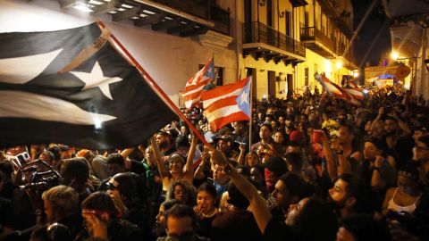 Puerto Ricans wave flags in celebration of Rosselló's resignation.