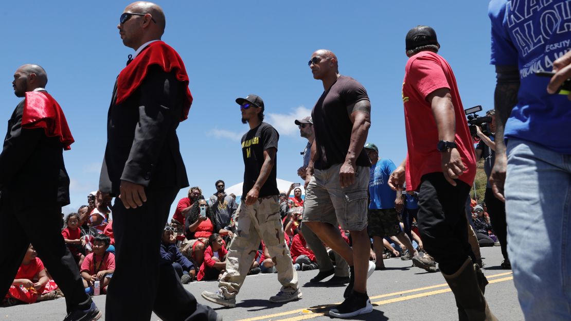 Actor Dwayne "The Rock" Johnson, third from right, walks with telescope protesters during his visit to the base of Mauna Kea.