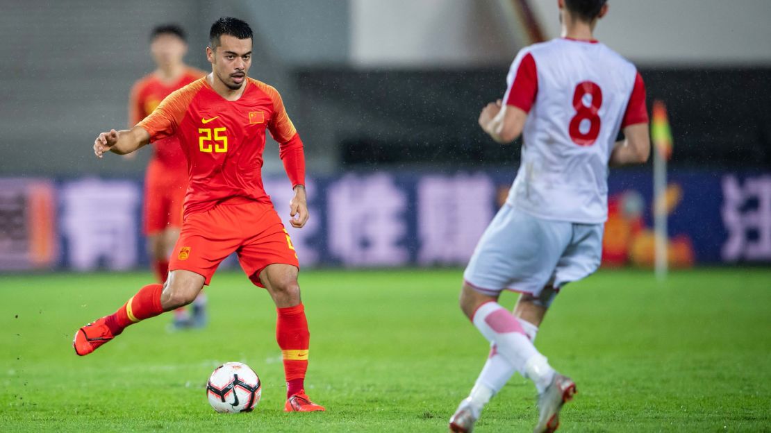 China's Nico Yennaris (L), known as Li Ke in Chinese, is challenged by Muhammadjon Rahimov of Tajikistan during a friendly in Guangzhou.
